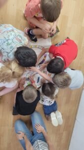 ילדים יושבים במעגל ויוצרים עבודה משותפת בקבוצת הכנה לכתה א'